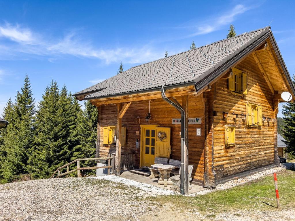 a log cabin with a yellow door and a table at 1A Chalet Enzianhuette - im Wander und Skigebiet in Elsenbrunn
