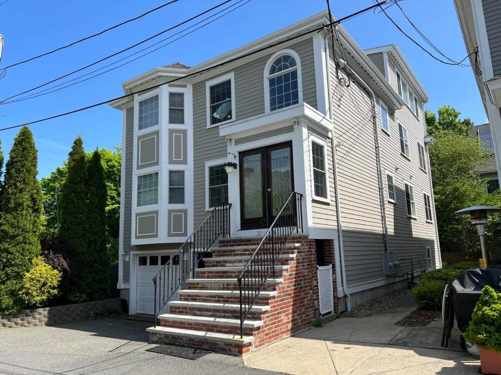 a white house with stairs in front of it at Swampscott Retreat Four Bedrooms Come Unwind in Swampscott