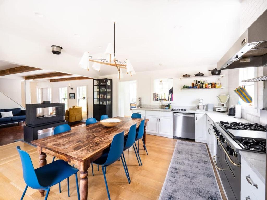 a kitchen with a wooden table and blue chairs at Berkshire Vacation Rentals: Stunning 1860 Farmhouse Private Pond & Hot Tub in Taghkanic