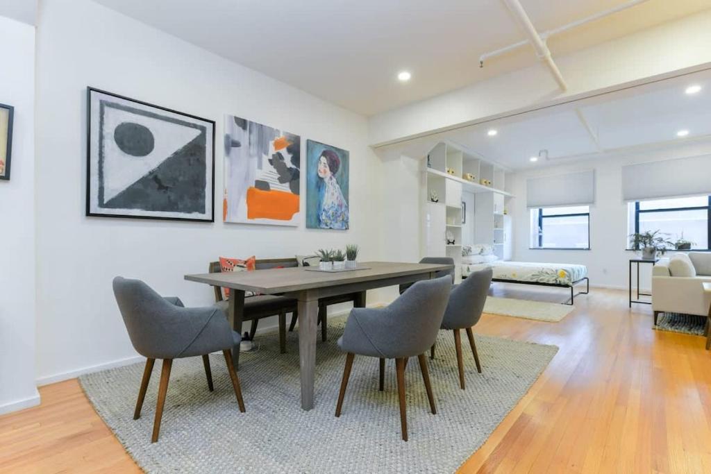 a living room with a dining room table and chairs at South End Hospitality: Downtown Crossing Large Lofted Condo Location in Boston
