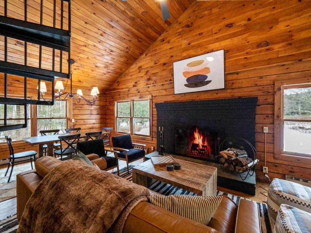 Cabaña de madera con sala de estar con chimenea en Berkshire Vacation Rentals: Private Cabin On Over 12 Acres Of Woods, en Becket