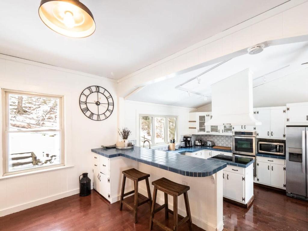 cocina con armarios blancos y encimera negra en Berkshire Vacation Rentals: Chic Pittsfield Home With A View, en Pittsfield