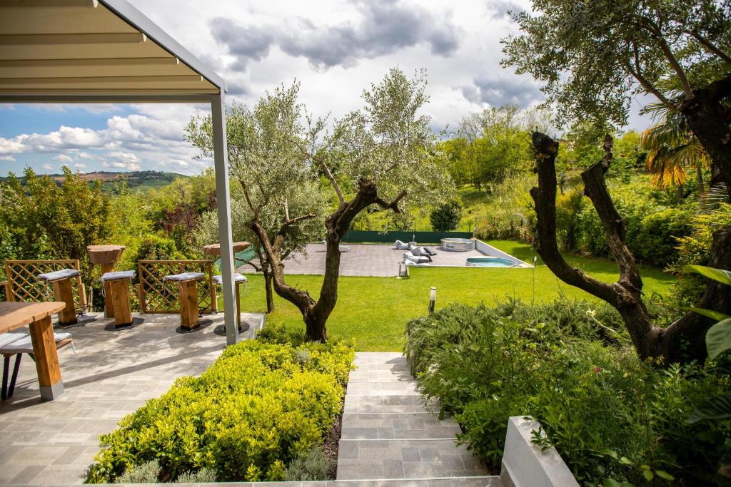 een patio met een tafel en bomen in een tuin bij Villa Green Paradise in Castel San Pietro Terme