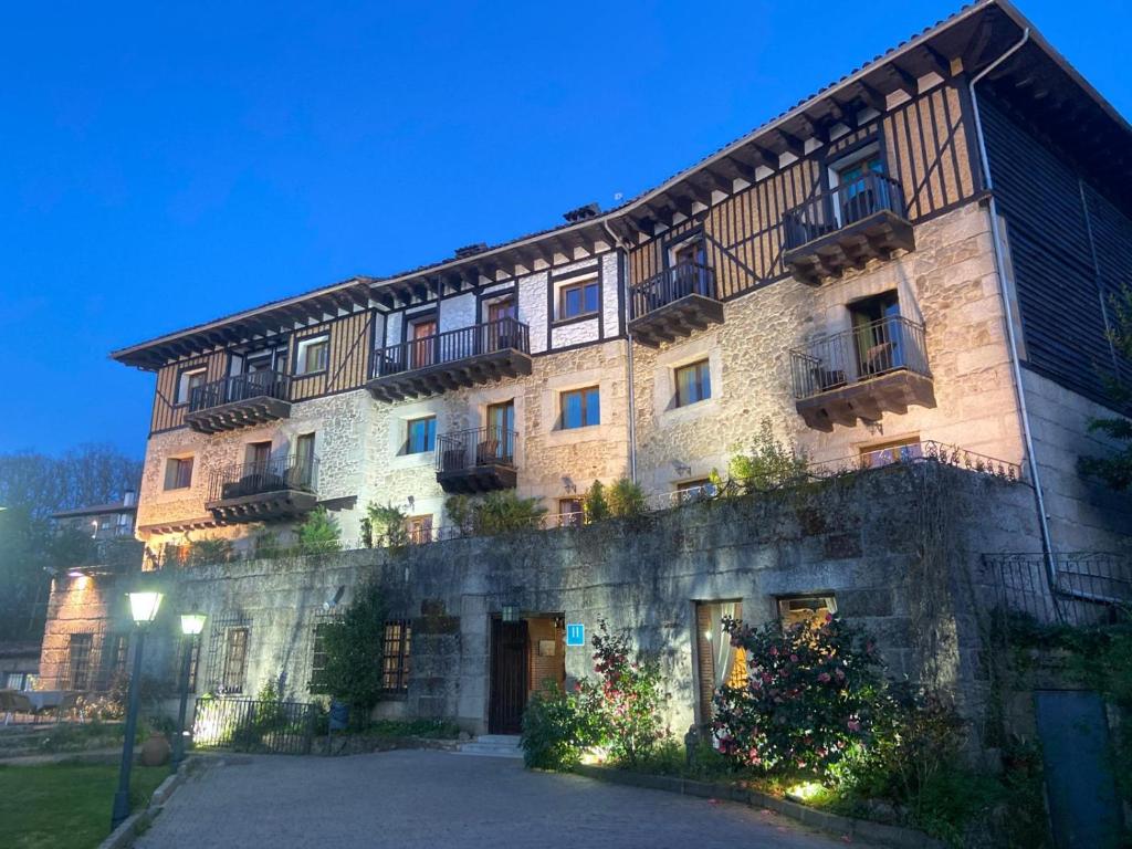 un gran edificio de piedra con balcones. en Hotel Doña Teresa, en La Alberca