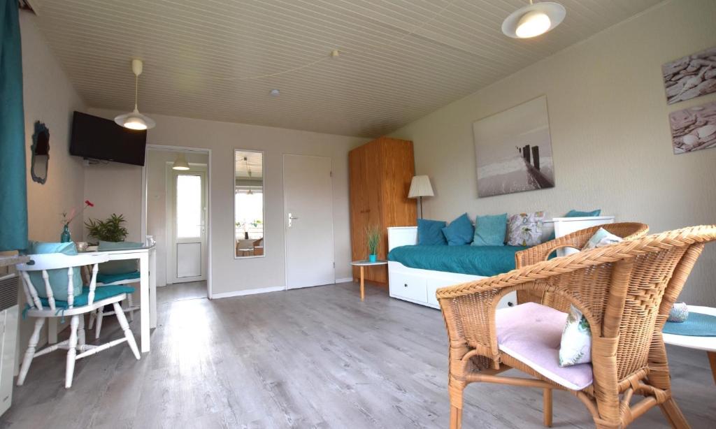 Bungalow "Ostseehus" في Grömnitzerhagen: غرفة معيشة مع أريكة زرقاء وطاولة