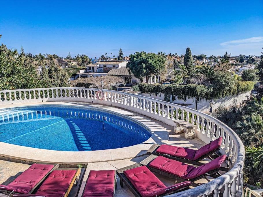 una piscina con tumbonas junto a un complejo en Panoramic views & pool. 4 mins to beach, en Santa Fe de los Boliches