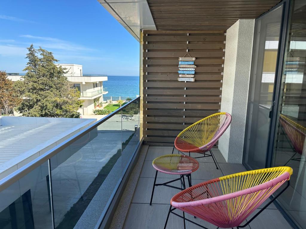 a balcony with two chairs and a view of the ocean at Astria by the Sea Apartment in Olimp