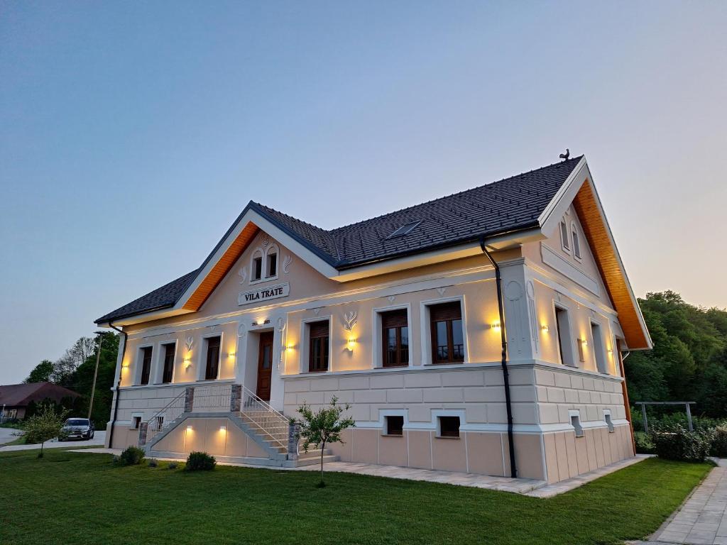 Vila Trate في Križevci pri Ljutomeru: منزل أبيض كبير مع أضواء عليه