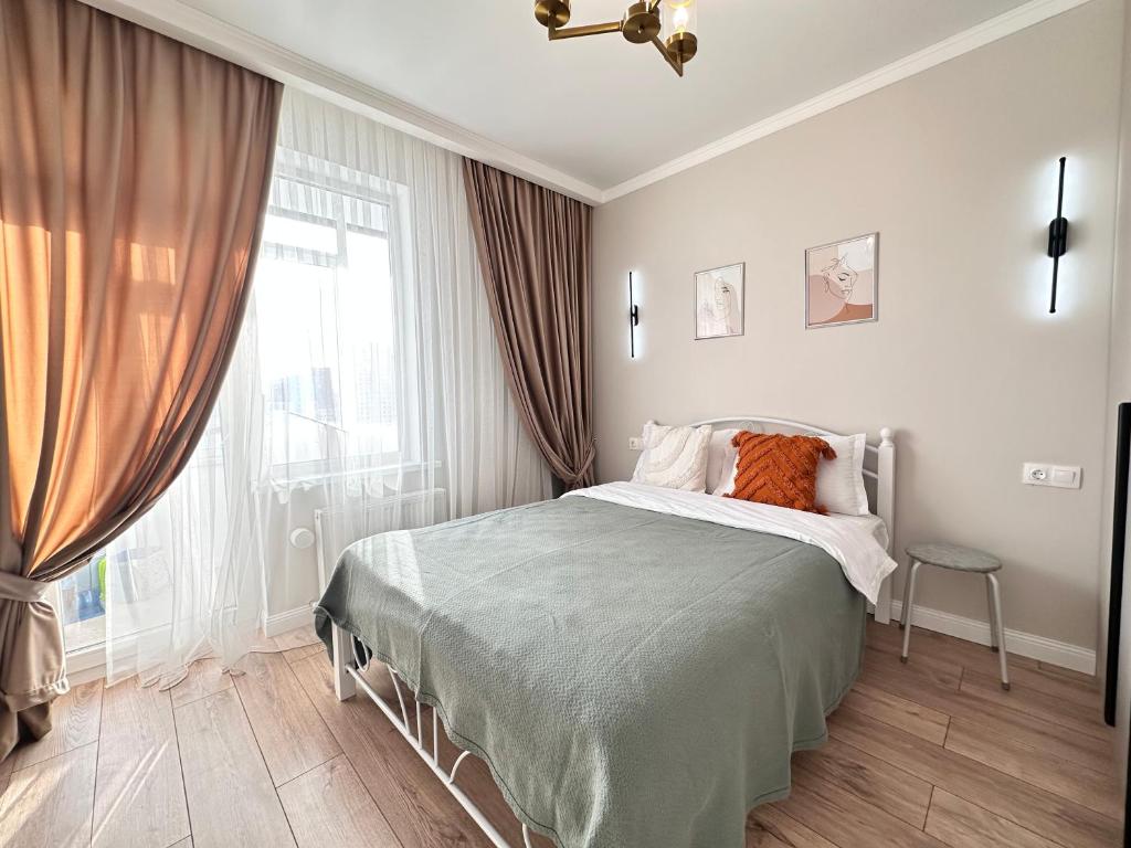 een slaapkamer met een bed en een groot raam bij Сердце Столицы in Astana