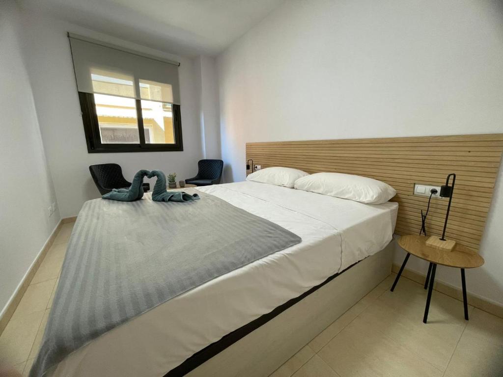 - une chambre avec un grand lit blanc et une fenêtre dans l'établissement Apartament Mar Beach Lloret, à Lloret de Mar
