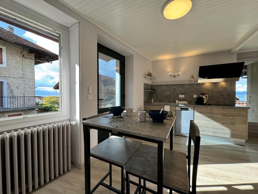uma cozinha com mesa e cadeiras e uma janela em Les Hauteurs de Lugrin - Maison de Vacances em Lugrin