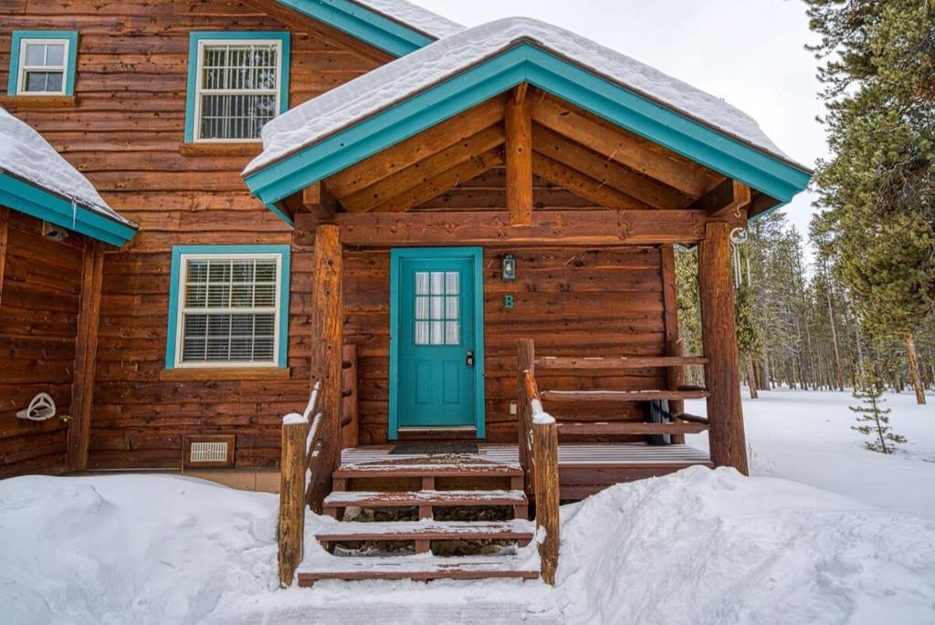 Cabaña de madera con puerta azul en la nieve en Trapper`s Treasure 5B en Leadville