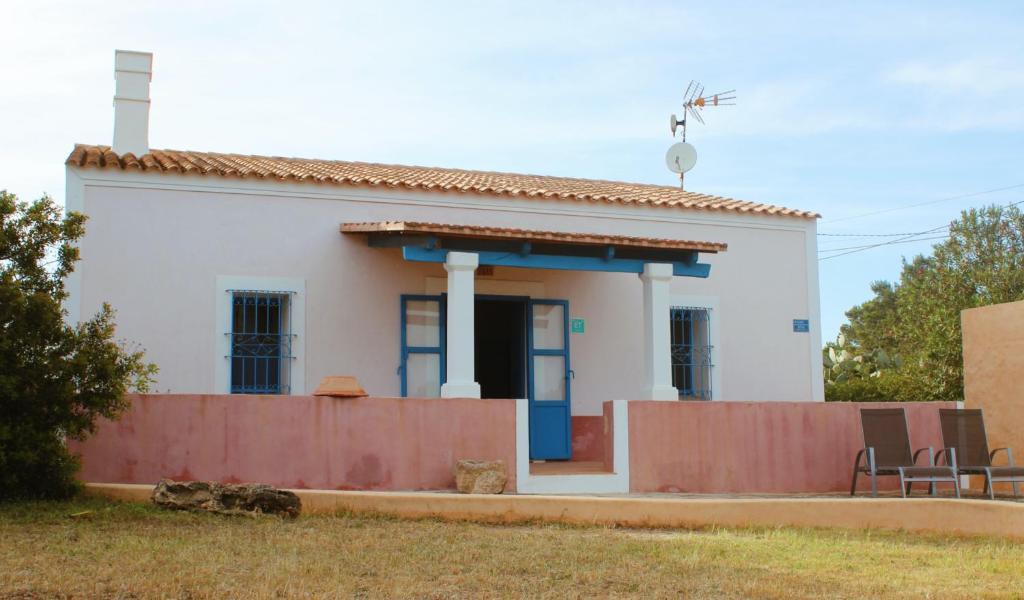une petite maison blanche avec une clôture devant elle dans l'établissement CAN TONI DEN MESTRE, à Cala Saona