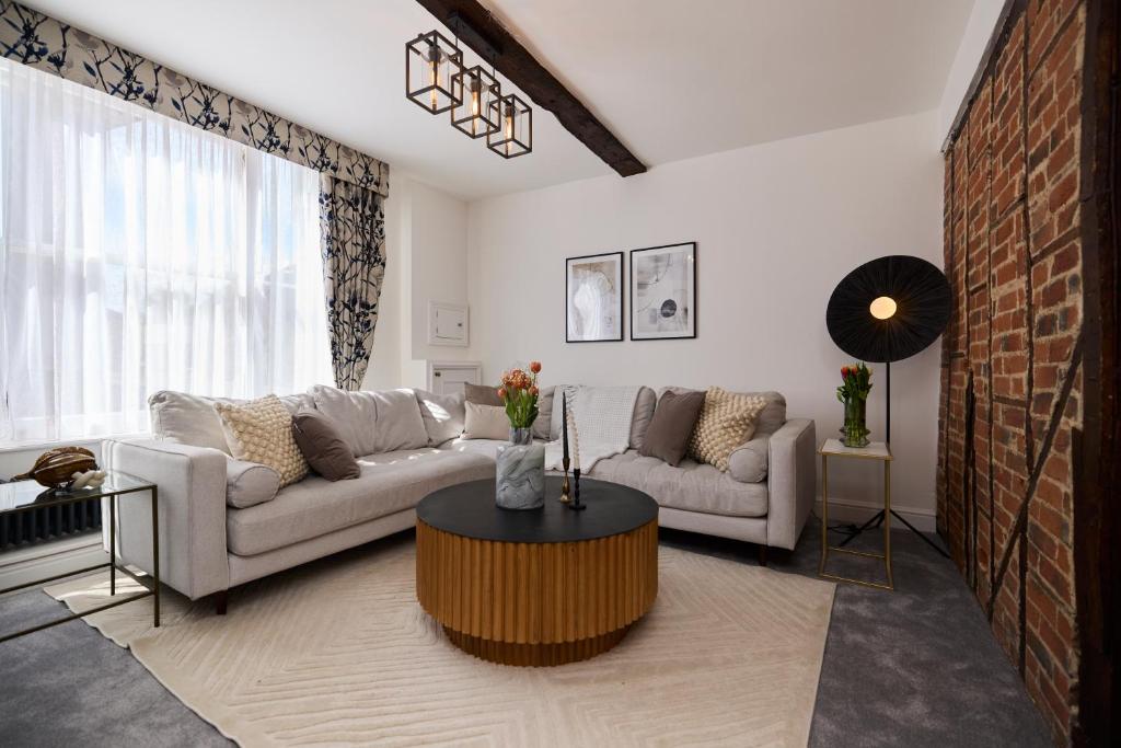 un soggiorno con divano e tavolo di The Old Hatfield Haven - Spacious 6BDR House with Garden a Hatfield
