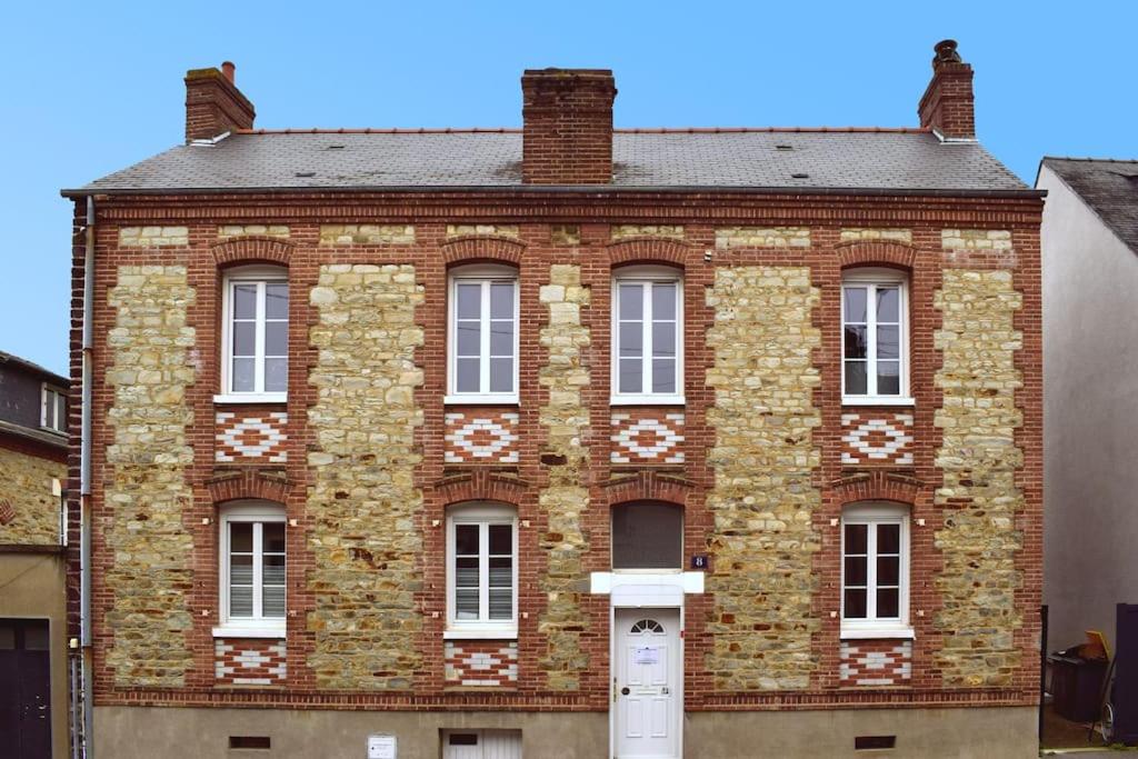 - un bâtiment en briques rouges avec des fenêtres blanches et une porte dans l'établissement Chez David et Bene, à Rennes