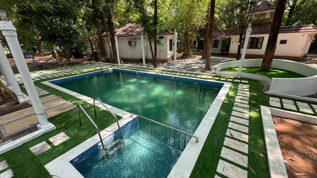 a swimming pool in the yard of a house at Surya Eco and Wedding Resort in Trichūr