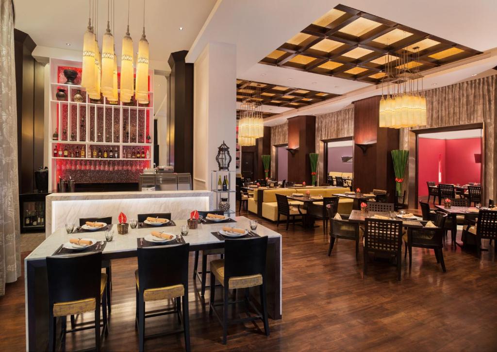 a dining room with tables and chairs and a restaurant at Sheraton Grande Sukhumvit, a Luxury Collection Hotel, Bangkok in Bangkok