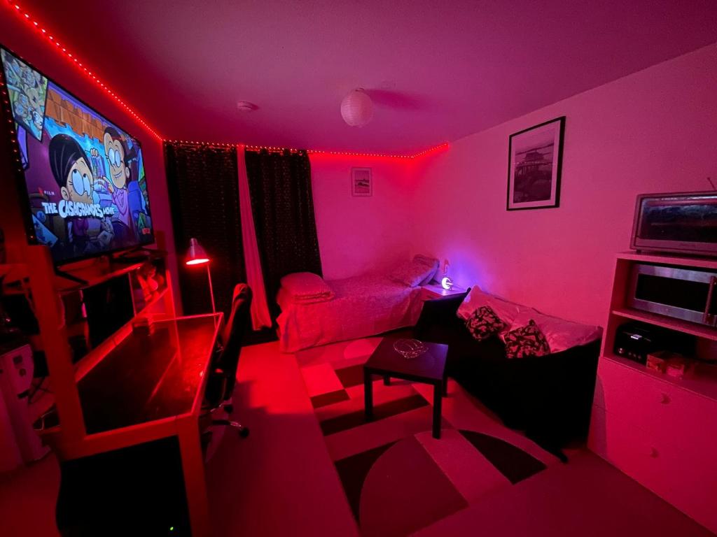 a living room with pink lights and a tv at Logement Cosy pour Deux ou Trois - Parfait pour les Jeunes ou Étudiants in Montpellier