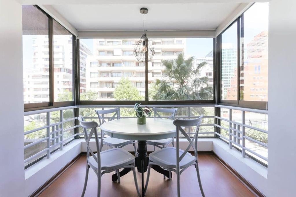 a balcony with a table and chairs and windows at Silver City with Parking & Wifi in Santiago