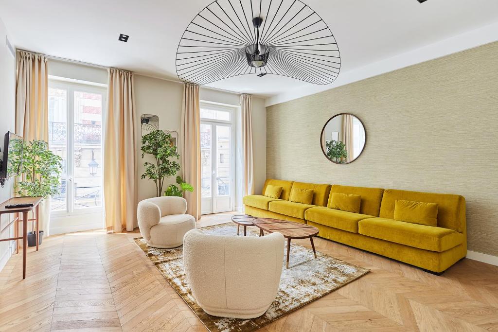 un salon avec un canapé jaune et une table dans l'établissement Apartement Place Vendome by Studioprestige, à Paris