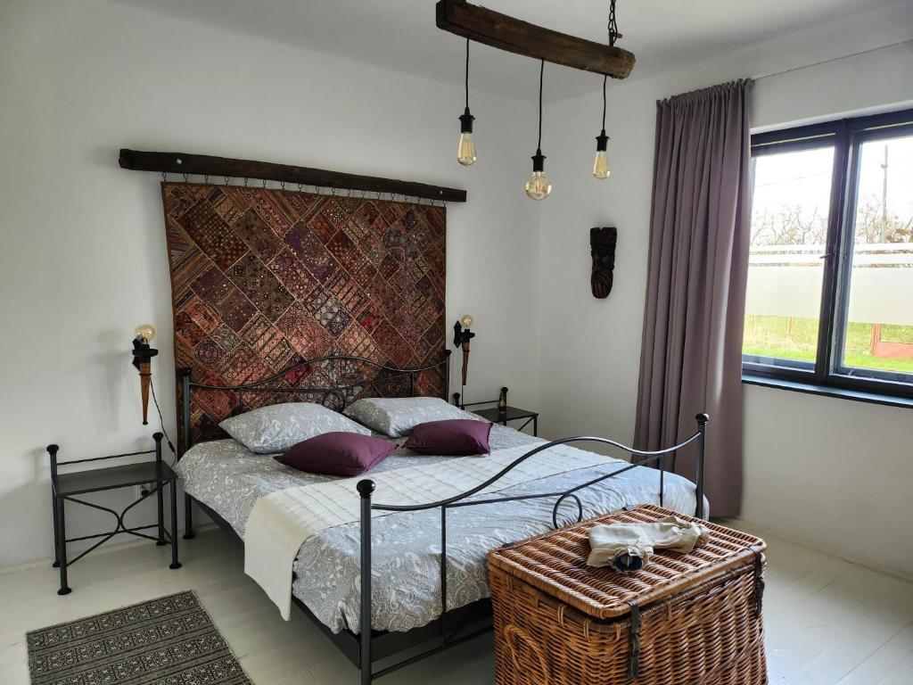 1 dormitorio con 1 cama con almohadas moradas en Moongardenhouse, en Kováčovce