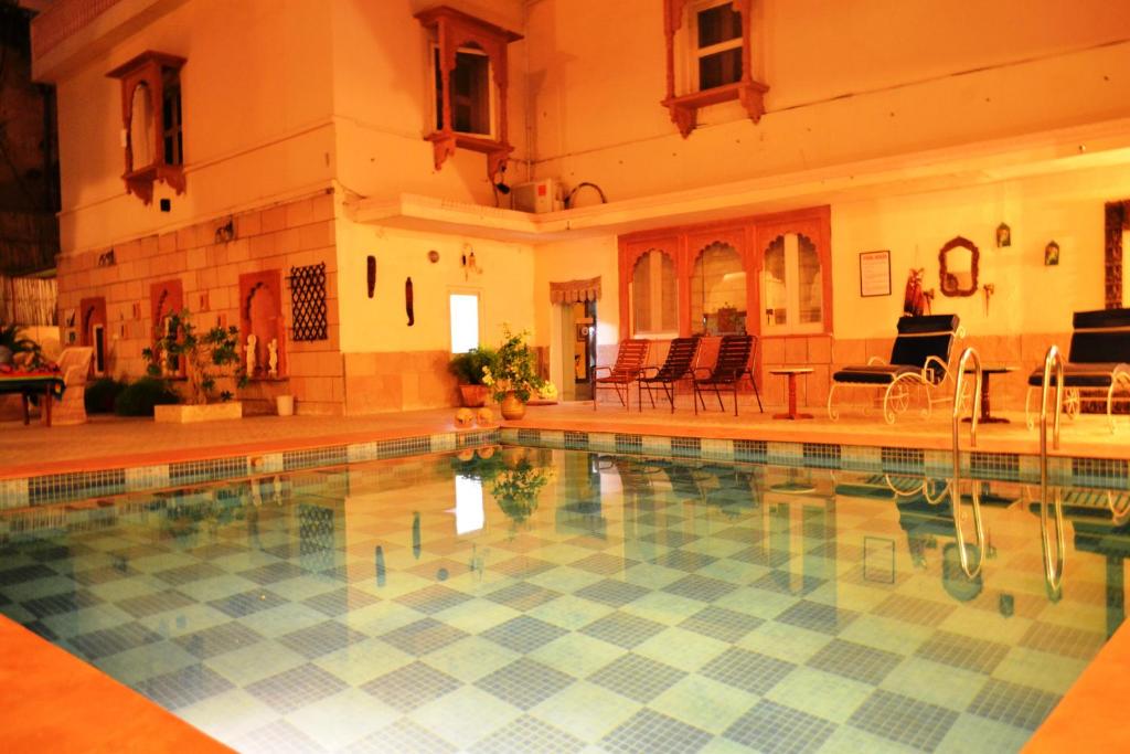 a large swimming pool in a large house at Suryaa Villa - A Boutique Heritage Hotel in Jaipur