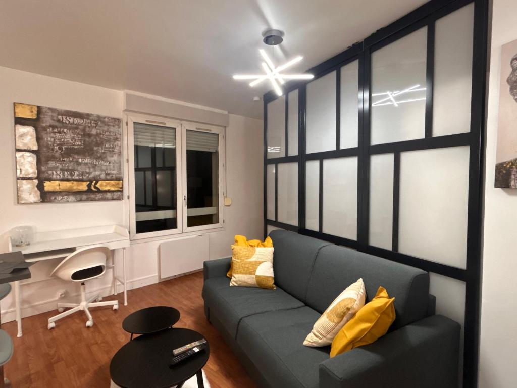 a living room with a couch and a desk at Modern Home proche de Disneyland et Paris in Champs-Sur-Marne