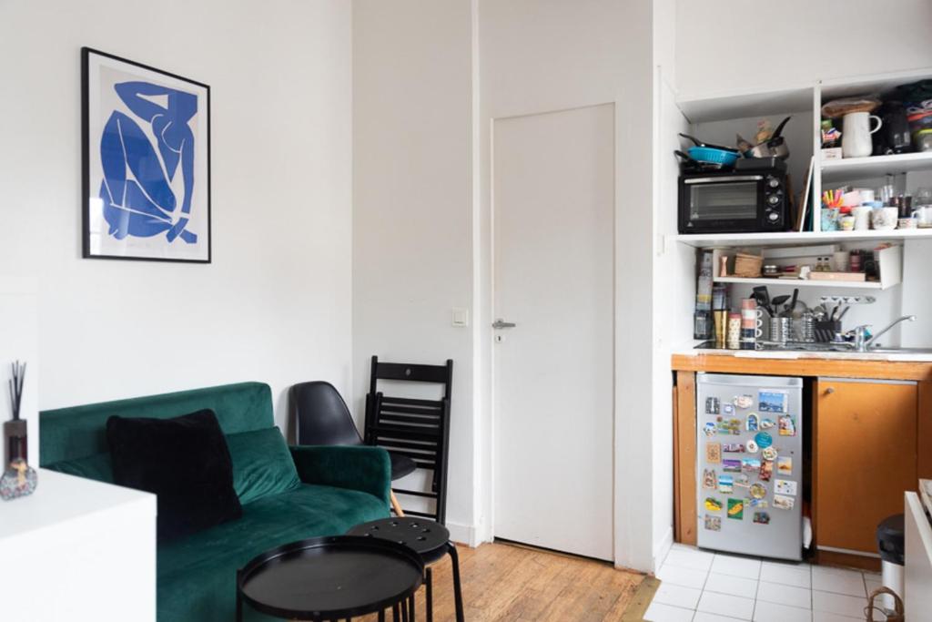 Il comprend un salon avec un canapé vert et une cuisine. dans l'établissement Beautiful Apartment In The Heart Of Paris, à Paris