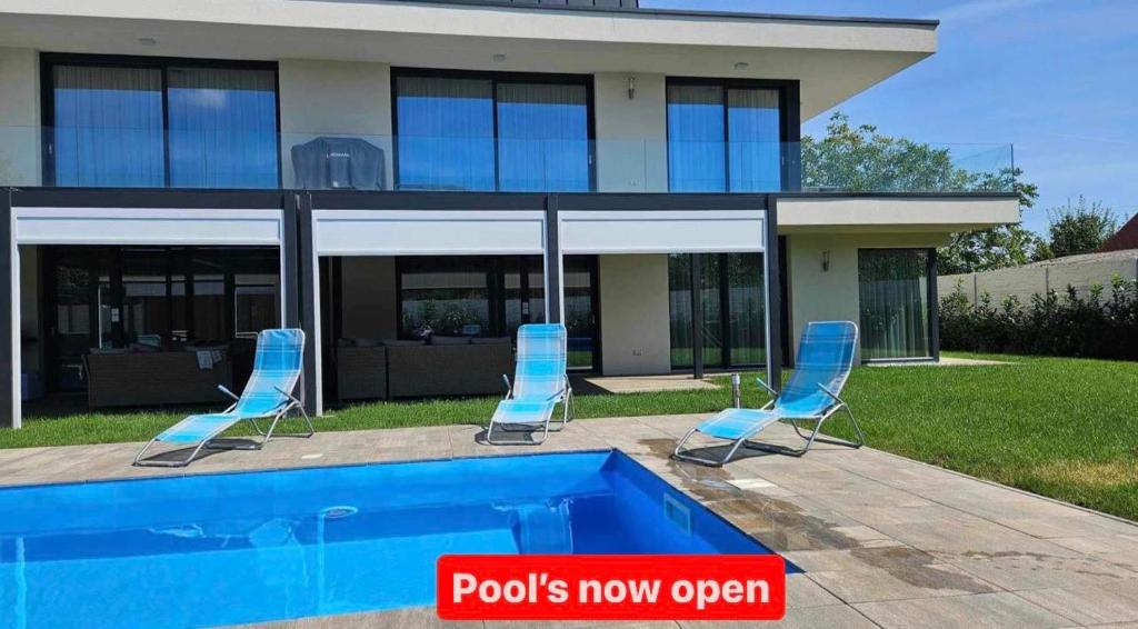 a house with two chairs and a swimming pool at Luxury Apartments in Balatonalmádi, Almádi Lux Apartman I - Ocean Blue in Balatonalmádi