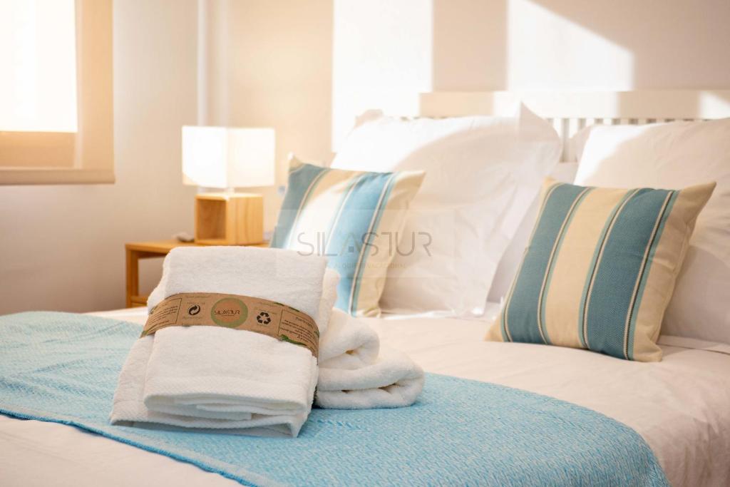 Habitación con cama con toallas y almohadas en Casa Andrés Apartamento, en Oviedo