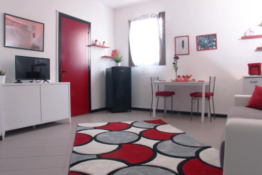 a living room with a red door and a red and white rug at The Relax Apartment - Le Cà De Boron in Montagnana