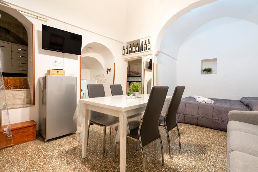 sala de estar con mesa blanca y sillas negras en Casa Vita 51, en Ceglie Messapica