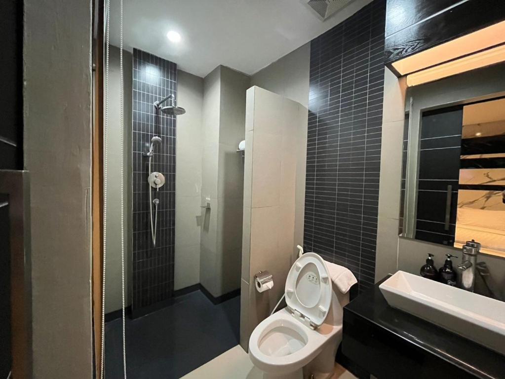 ein Bad mit einem WC, einem Waschbecken und einer Dusche in der Unterkunft Sky dome resotel in Bangkok