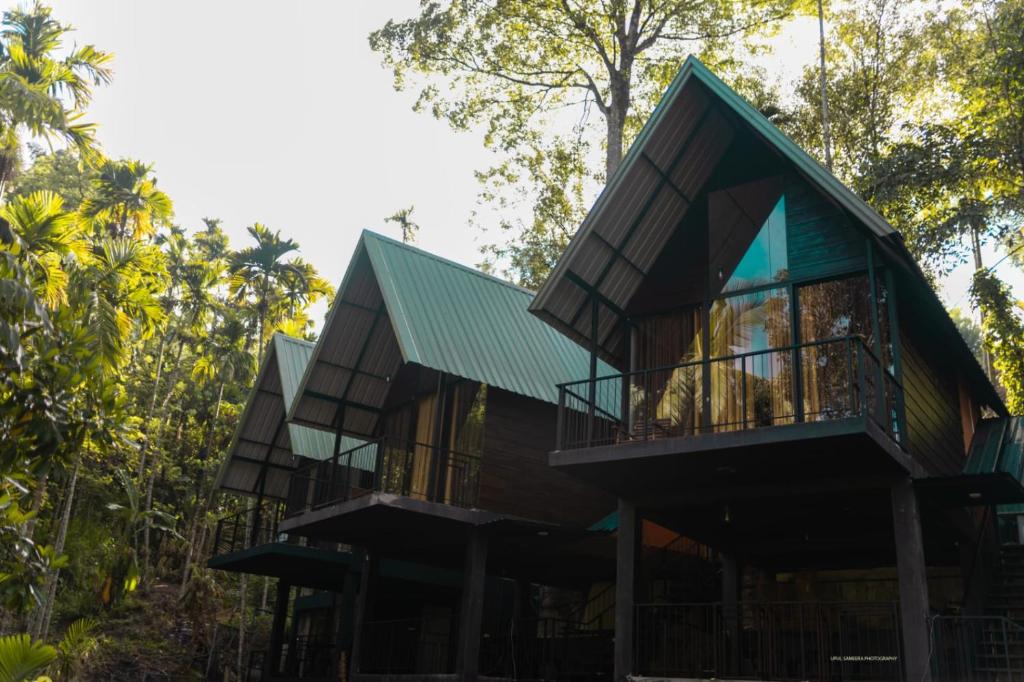 una casa en el bosque con un techo verde en Eco Knuckles Holiday Lodge, en Kandy