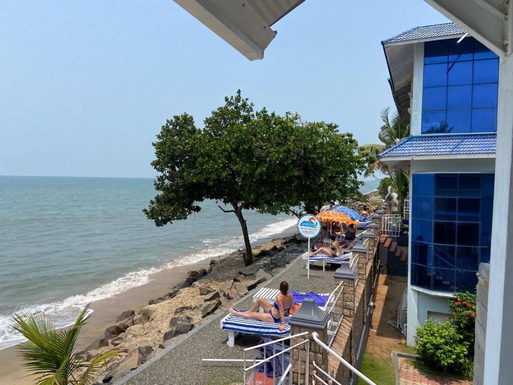 - un groupe de personnes assises sur des chaises longues sur la plage dans l'établissement Sealine Beach Resorts, à Cherai Beach