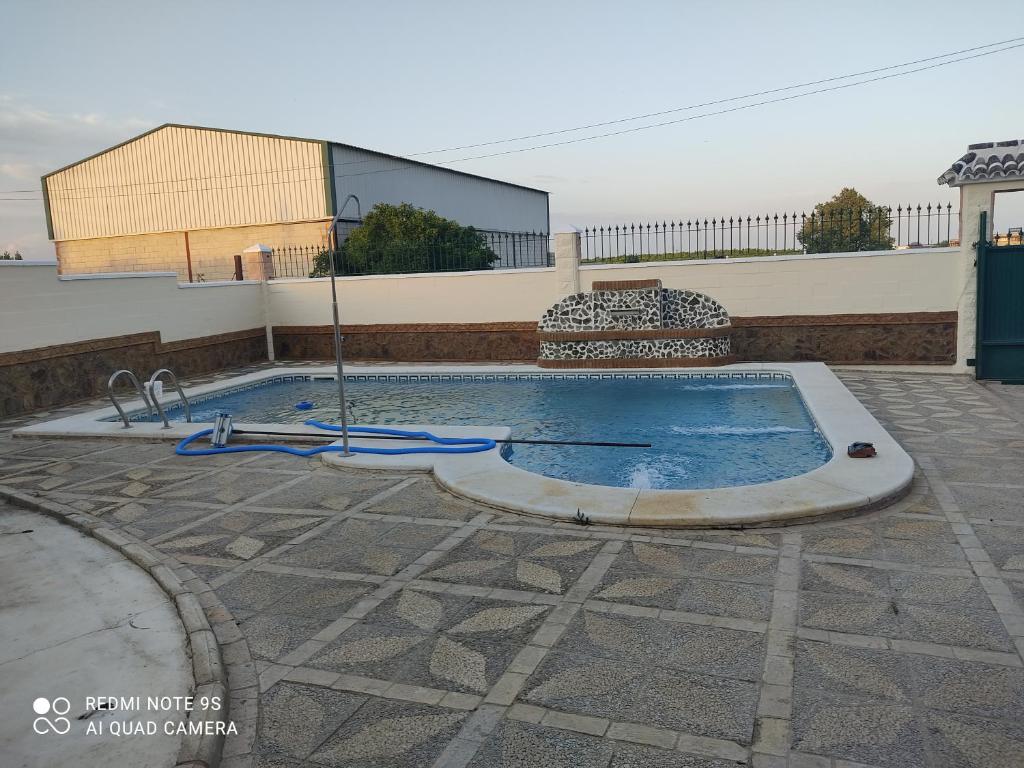 einen Pool mit blauem Schlauch im Innenhof in der Unterkunft Casa rural pilas in Pilas