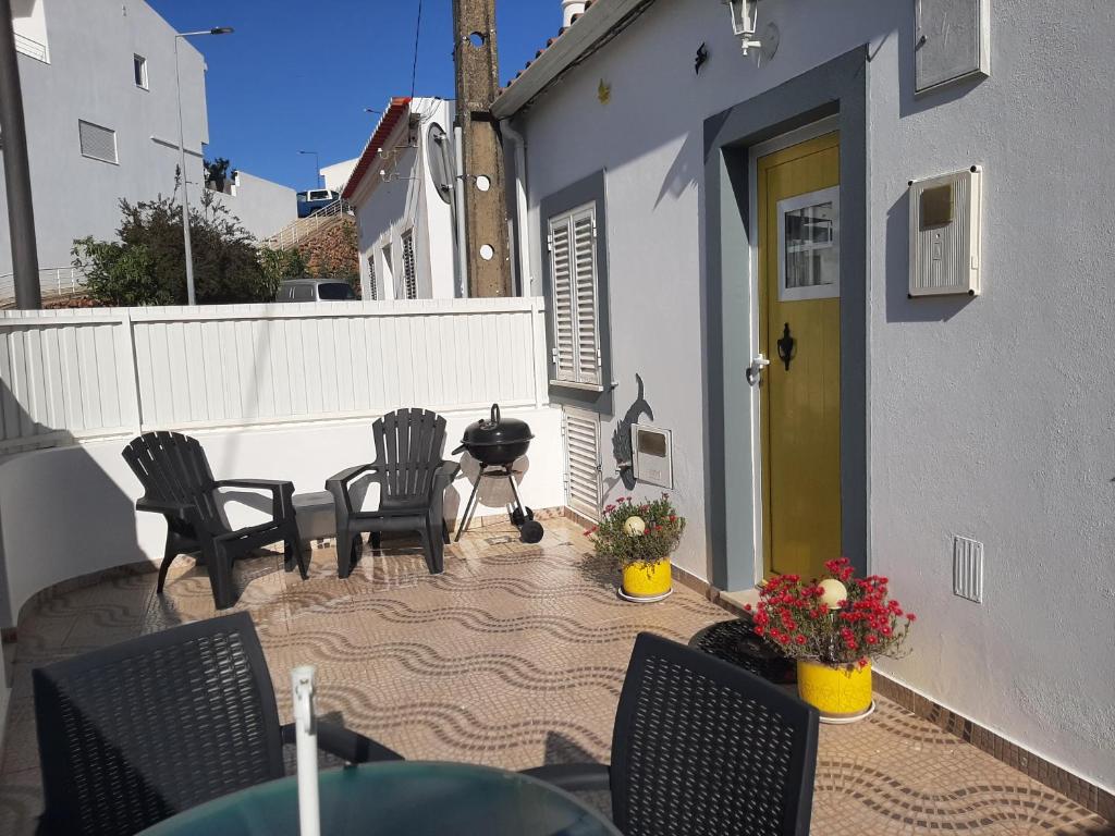 a patio with chairs and a table and a grill at Ferragudo Cozy Studio in Ferragudo