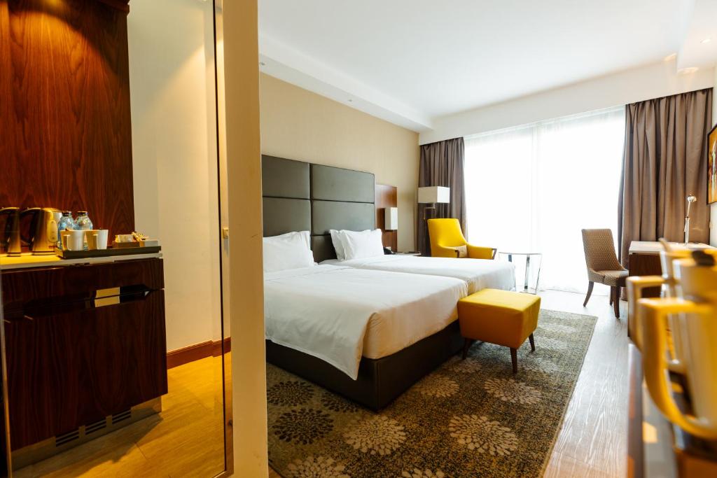 a hotel room with a bed and a chair at Crowne Plaza Nairobi Airport by IHG in Nairobi