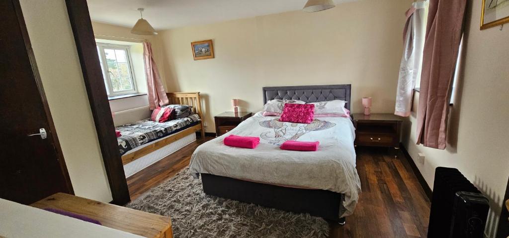 a bedroom with a bed with pink pillows on it at Trelawney Cottage, Sleeps up to 4, Wifi, Fully equipped in Menheniot