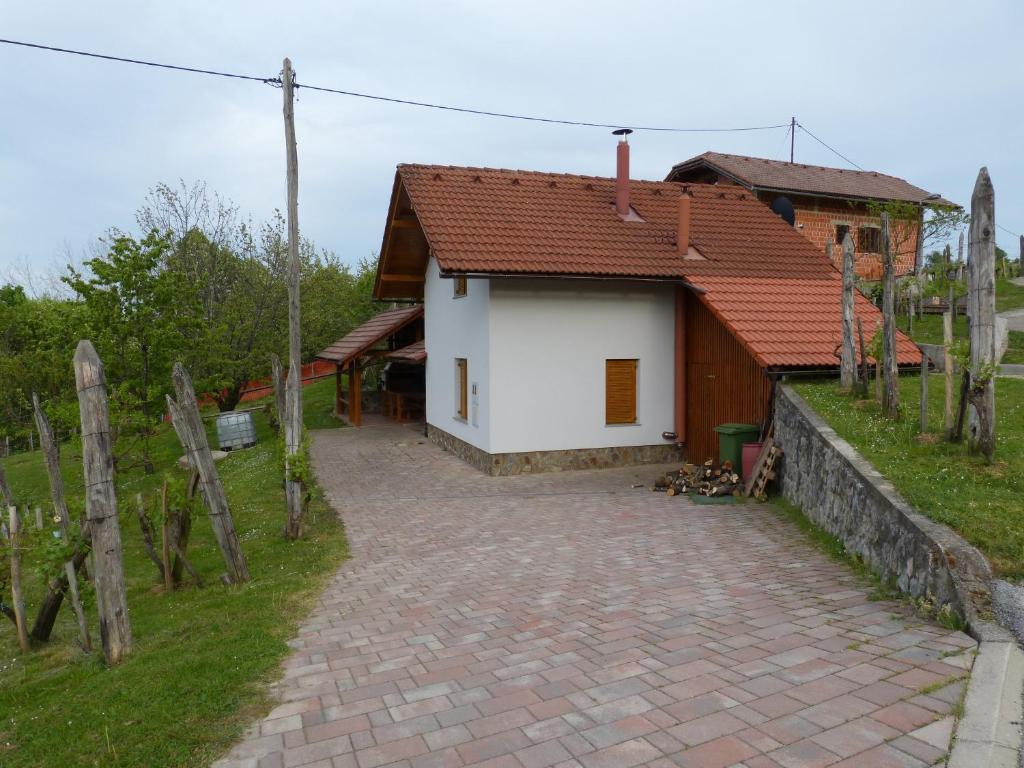 ein kleines weißes Haus mit einer steinernen Einfahrt in der Unterkunft Vineyard cottage Mavrica in Dragatuš