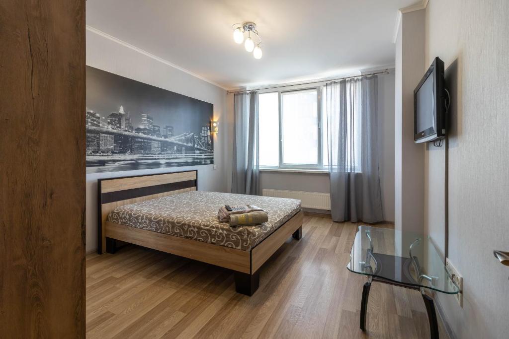 um quarto com uma cama, uma televisão e uma janela em Kvartirkoff na Bogatirskaya 6a, 3 floor em Kiev