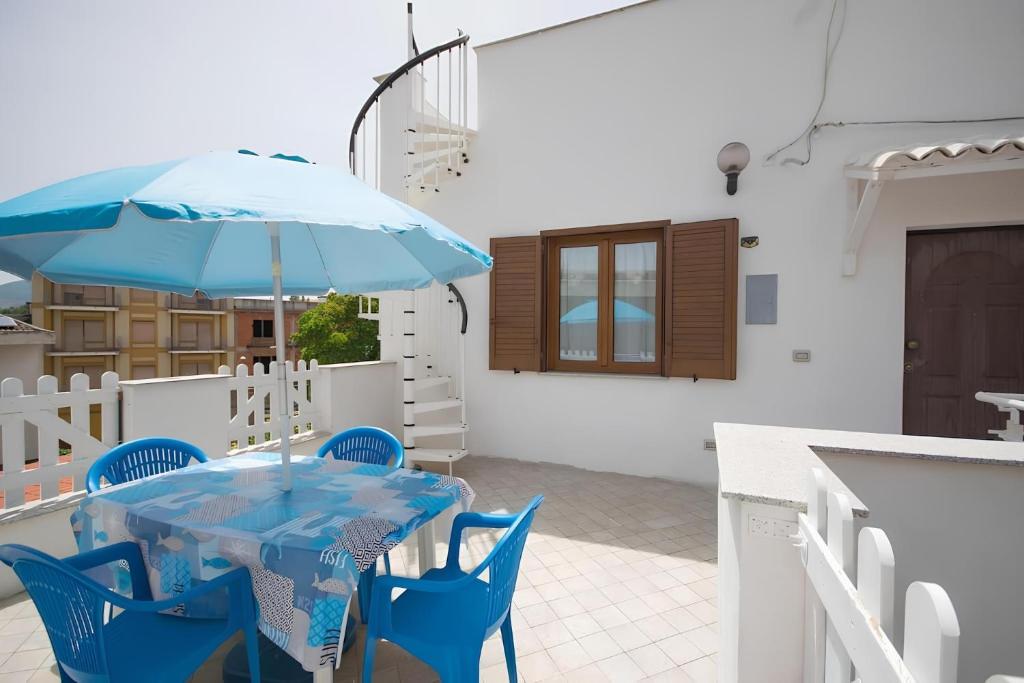 einen blauen Tisch und Stühle mit Sonnenschirm auf einer Terrasse in der Unterkunft La Corte Sarda Centro Storico a 5min di auto dal mare in Siniscola