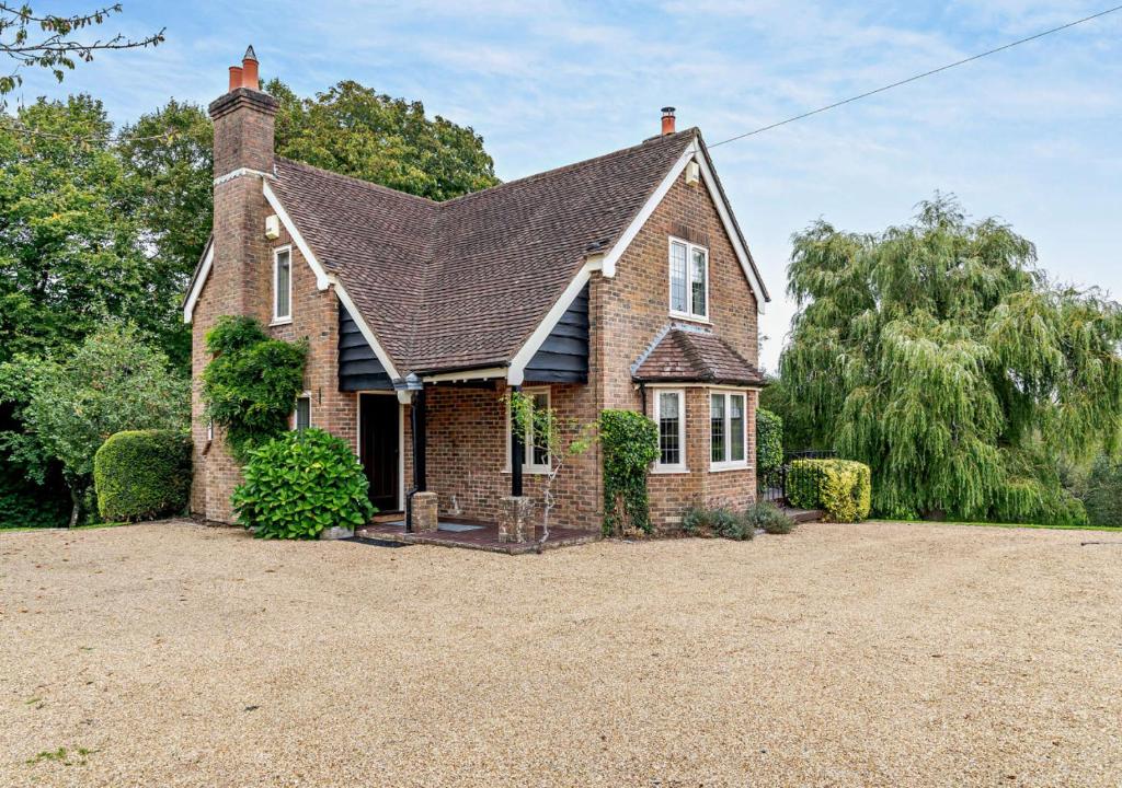 an old brick house with a large driveway at Throop House Cottage - Bournemouth in Bournemouth