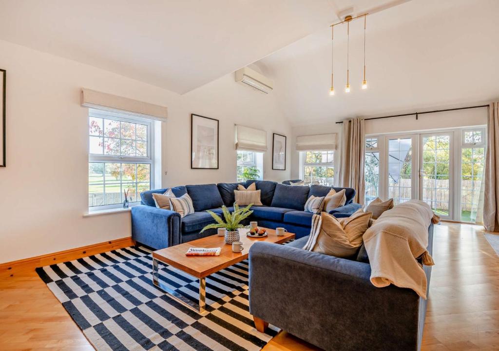 uma sala de estar com um sofá azul e uma mesa em The Castleman em Ferndown