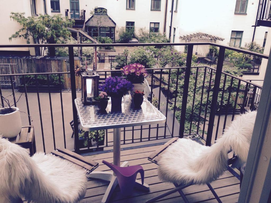 un balcón con 2 sillas y una mesa con flores en Birkastan - Stockholm, en Estocolmo