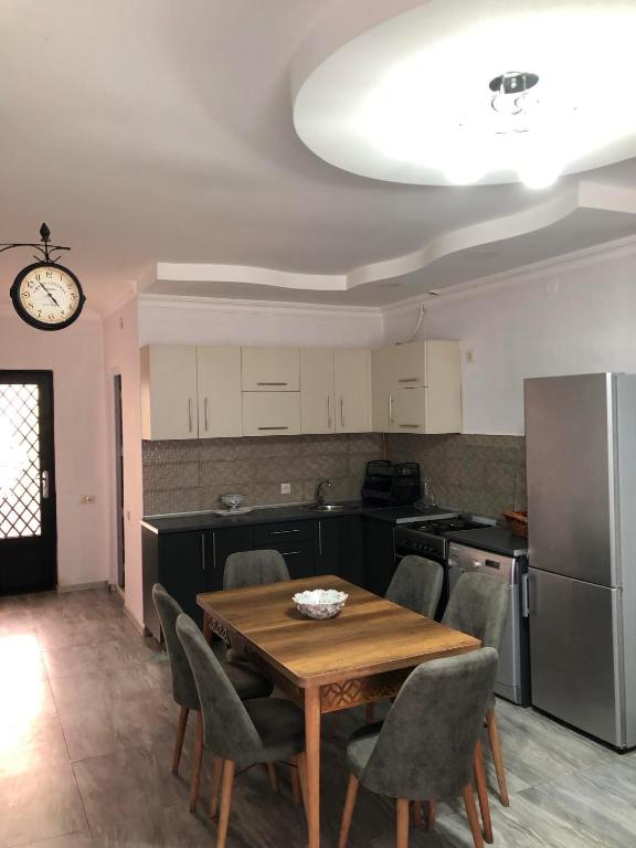 a kitchen with a table and chairs and a refrigerator at Cottage Gio in Kobuleti