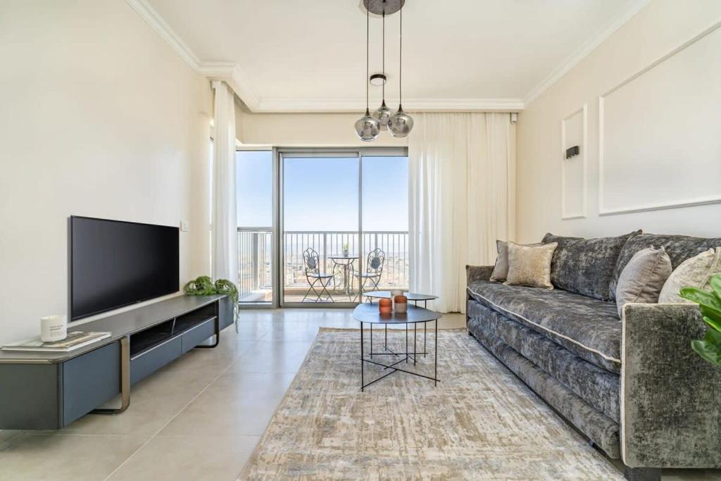 un soggiorno con divano e TV a schermo piatto di Savyon View Tower - Isrentals a Gerusalemme