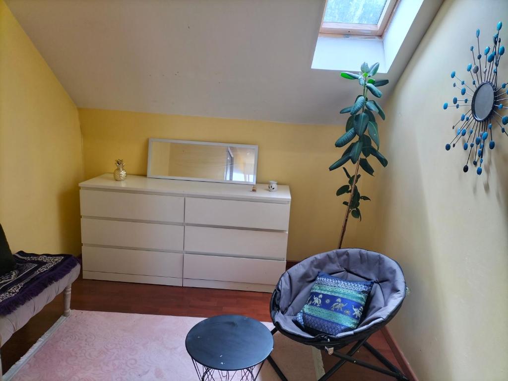 a room with a cabinet and a chair and a microwave at chez H&M in Saint-Cyr-lʼÉcole