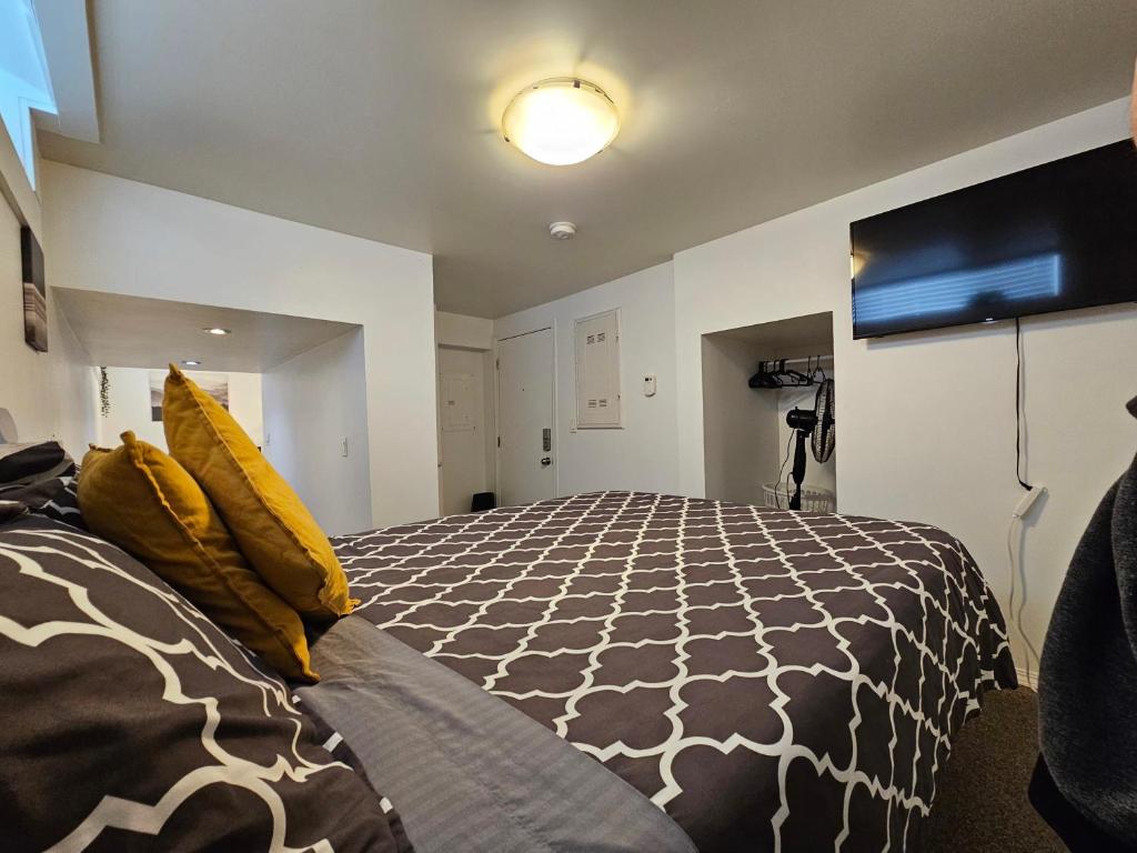 ein Schlafzimmer mit einem großen Bett mit gelben Kissen in der Unterkunft The MJ Tunnel Renovated Suite WiFi Parking in Moose Jaw