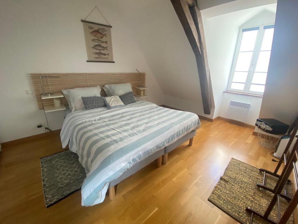 a bedroom with a large bed with a wooden floor at Appartement de charme rue du Château in Auray